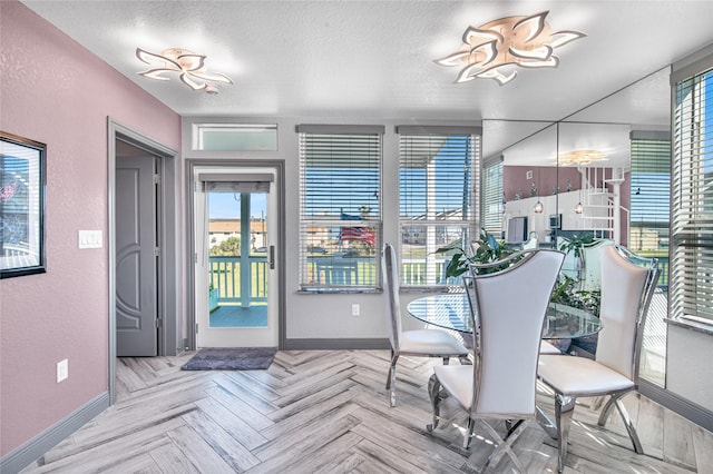 3709 Rice St, Galveston, TX 77554 - dining space featuring baseboards, a textured wall, and a textured ceiling