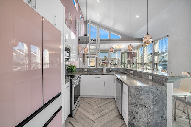 kitchen featuring white cabinets, sink, a kitchen bar, kitchen peninsula, and stainless steel appliances