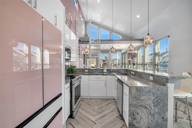 3709 Rice St, Galveston, TX 77554 - kitchen with appliances with stainless steel finishes, a sink, a kitchen bar, healthy amount of natural light, and recessed lighting