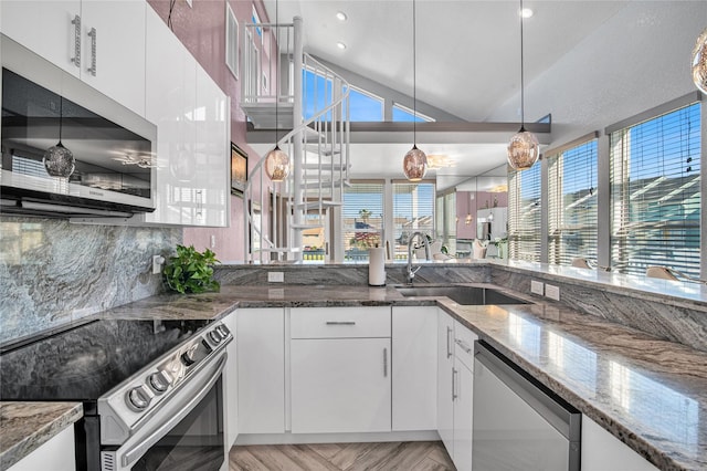 3709 Rice St, Galveston, TX 77554 - kitchen with stainless steel appliances, a sink, white cabinetry, stone counters, and vaulted ceiling