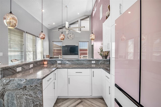 3709 Rice St, Galveston, TX 77554 - kitchen featuring high vaulted ceiling, white cabinetry, a ceiling fan, dark stone countertops, and decorative light fixtures