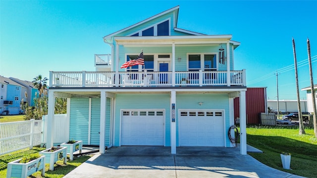 beach home featuring a balcony, a garage, and a front lawn