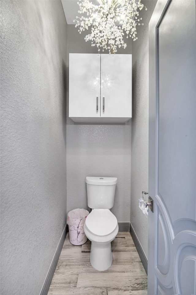3709 Rice St, Galveston, TX 77554 - bathroom with wood finished floors, toilet, baseboards, and a textured wall