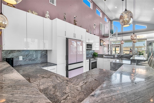 3709 Rice St, Galveston, TX 77554 - kitchen featuring appliances with stainless steel finishes, backsplash, white cabinetry, dark stone counters, and high vaulted ceiling