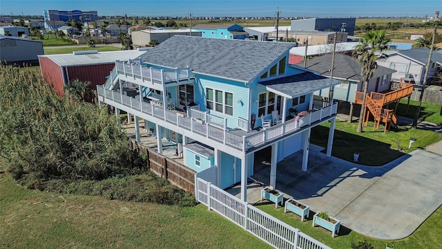 3709 Rice St, Galveston, TX 77554 - rear view of house with a shingled roof, an attached garage, and driveway
