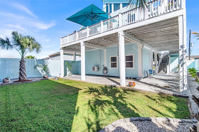 back of property featuring a deck, a patio area, and a lawn