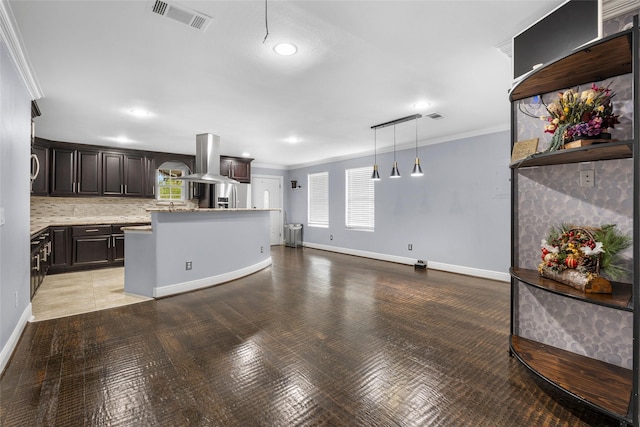 kitchen with pendant lighting, stainless steel fridge, island exhaust hood, and crown molding