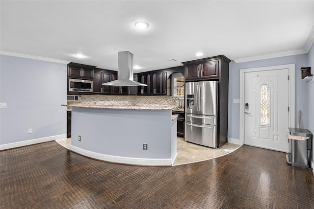 kitchen featuring a center island, backsplash, exhaust hood, appliances with stainless steel finishes, and dark brown cabinetry