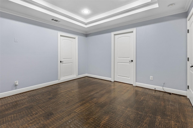 empty room featuring a raised ceiling and ornamental molding