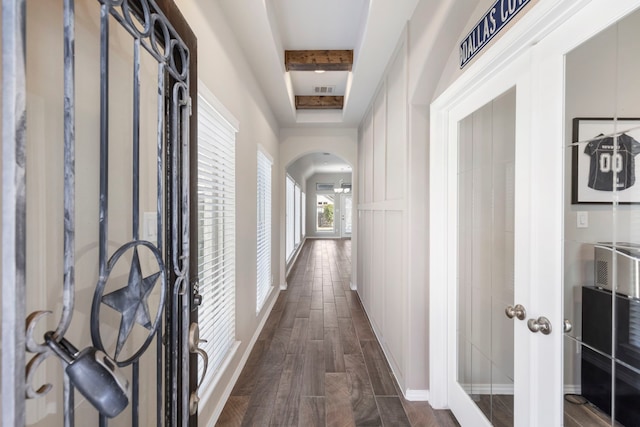 corridor featuring a raised ceiling and dark hardwood / wood-style flooring