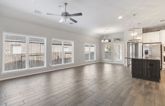 kitchen with dark stone countertops, dark hardwood / wood-style flooring, a healthy amount of sunlight, and decorative light fixtures