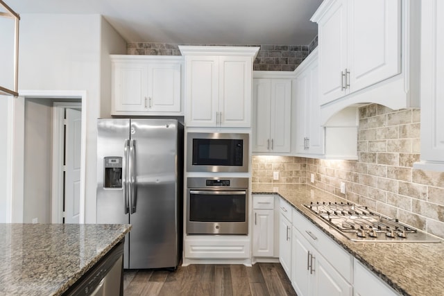 kitchen with white cabinets, appliances with stainless steel finishes, and dark hardwood / wood-style floors