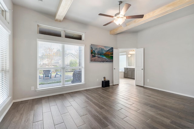 spare room featuring ceiling fan, beam ceiling, dark hardwood / wood-style flooring, and a wealth of natural light