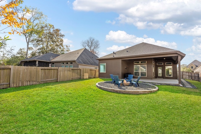 rear view of property featuring a fire pit, a patio area, and a yard