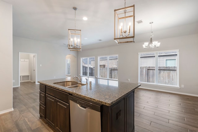 kitchen featuring sink, stainless steel dishwasher, an island with sink, dark hardwood / wood-style flooring, and light stone counters