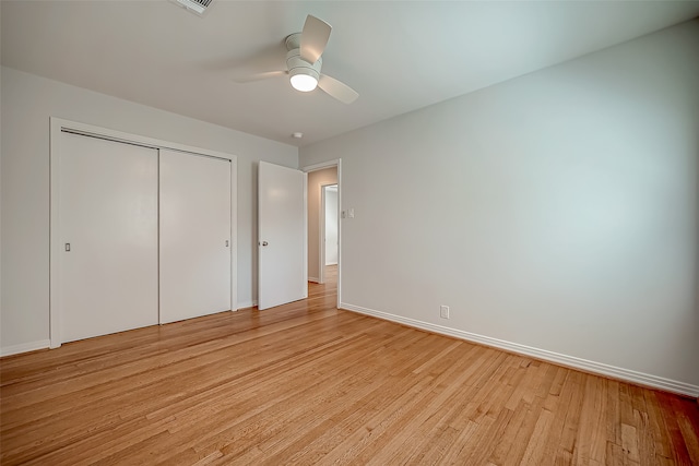 unfurnished bedroom with ceiling fan, light hardwood / wood-style flooring, and a closet