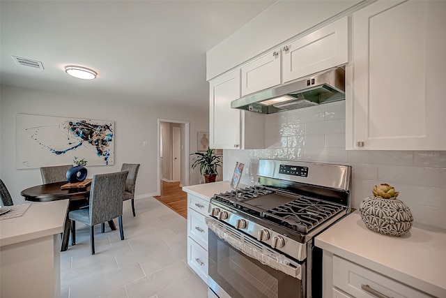 kitchen featuring white cabinets, stainless steel range with gas stovetop, and tasteful backsplash