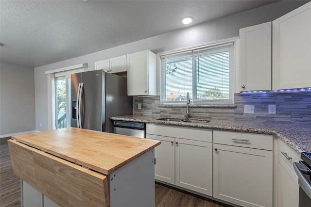 kitchen with a center island, white cabinets, sink, dark hardwood / wood-style flooring, and stainless steel appliances