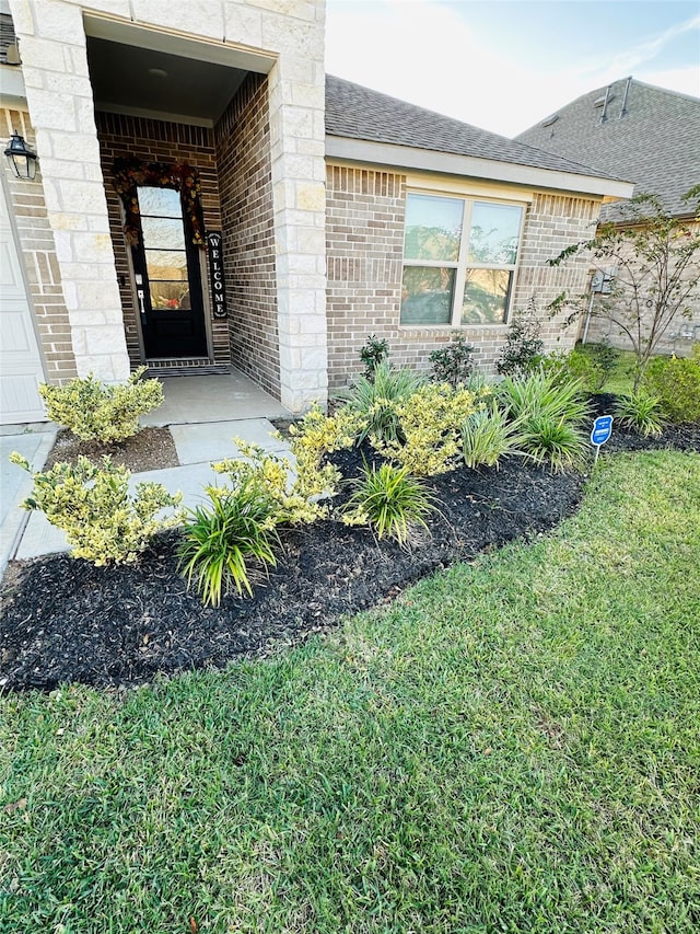 property entrance with a lawn