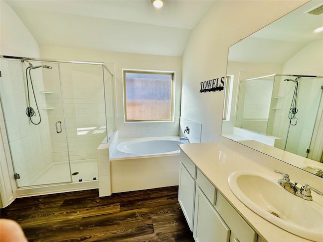 bathroom featuring hardwood / wood-style flooring, vanity, plus walk in shower, and vaulted ceiling