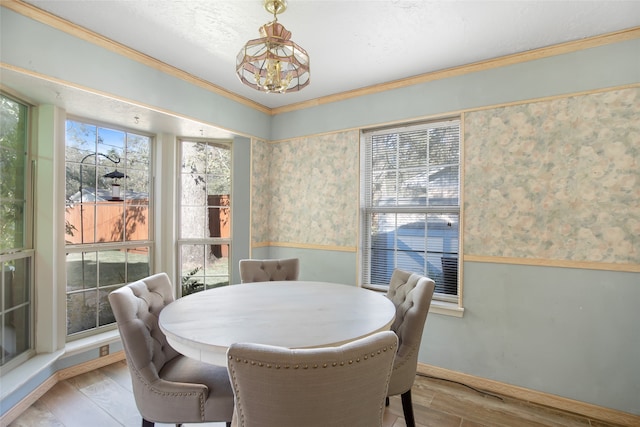 dining area featuring a chandelier, light hardwood / wood-style floors, and ornamental molding