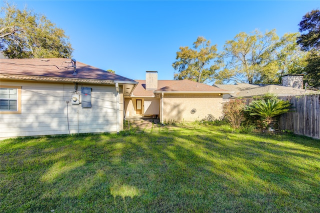 rear view of property with a lawn