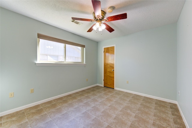 empty room featuring ceiling fan and a textured ceiling