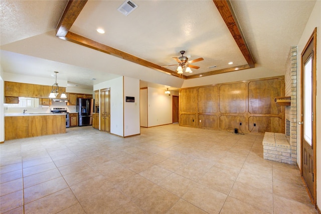 unfurnished living room with a tray ceiling, a wealth of natural light, and ceiling fan