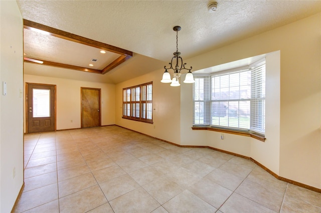 unfurnished room featuring a raised ceiling, light tile patterned floors, a textured ceiling, and an inviting chandelier