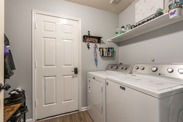 laundry room featuring washer and dryer and dark wood-type flooring