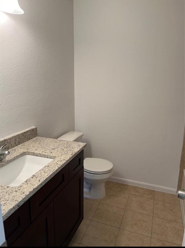 bathroom with tile patterned flooring, vanity, and toilet