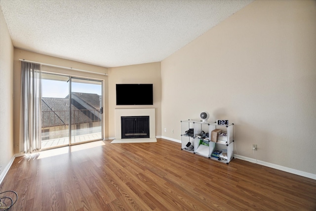 unfurnished living room with hardwood / wood-style flooring and a textured ceiling