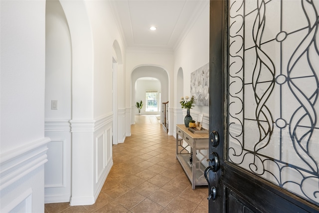 hall with crown molding and light tile patterned floors