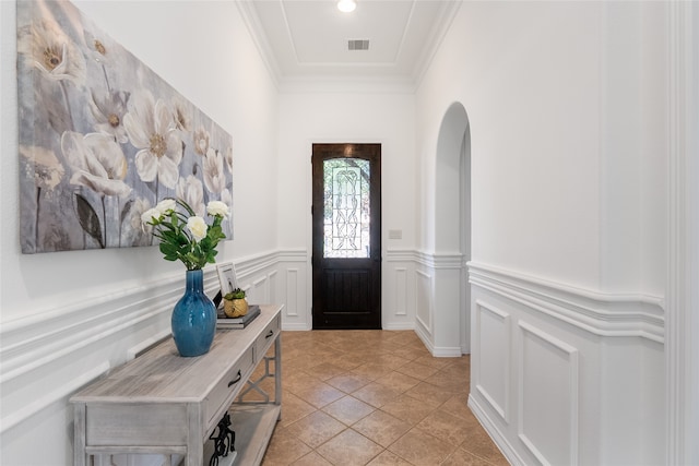 foyer with crown molding and light tile patterned flooring