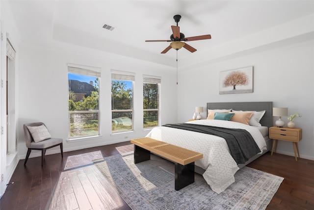 bedroom with dark hardwood / wood-style flooring and ceiling fan