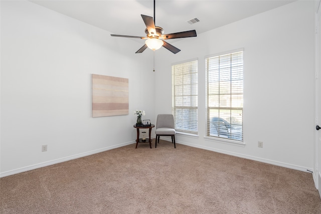 living area with carpet and ceiling fan