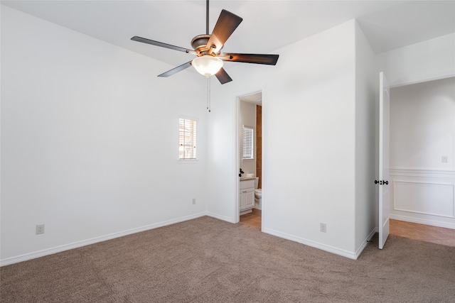 unfurnished bedroom featuring ceiling fan, light carpet, and connected bathroom