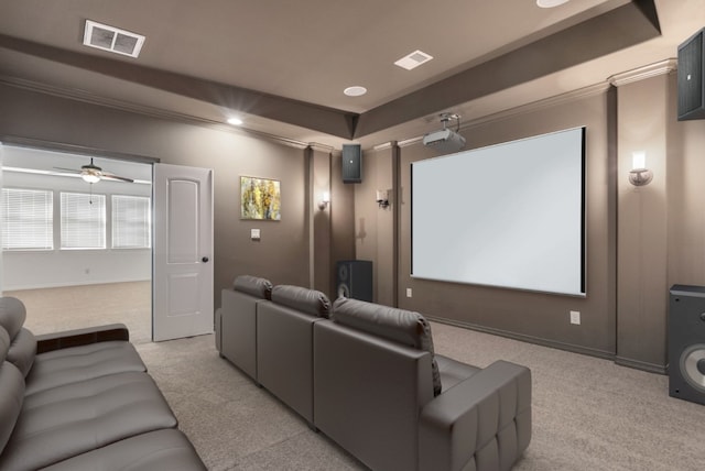 carpeted home theater room featuring ceiling fan and ornamental molding