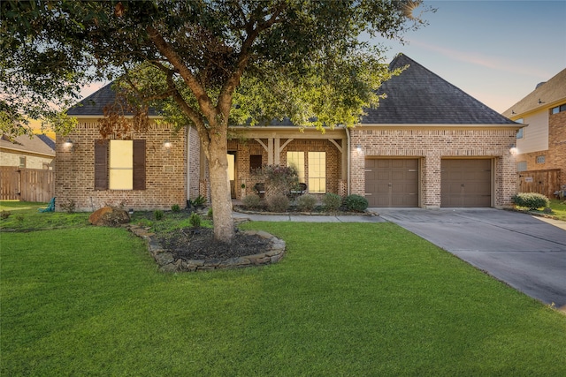 view of front of home with a garage and a lawn