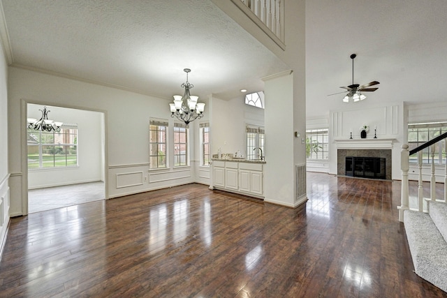 unfurnished living room with ceiling fan, dark hardwood / wood-style flooring, and a textured ceiling