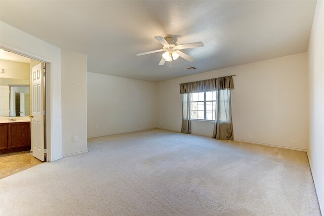 carpeted spare room featuring ceiling fan