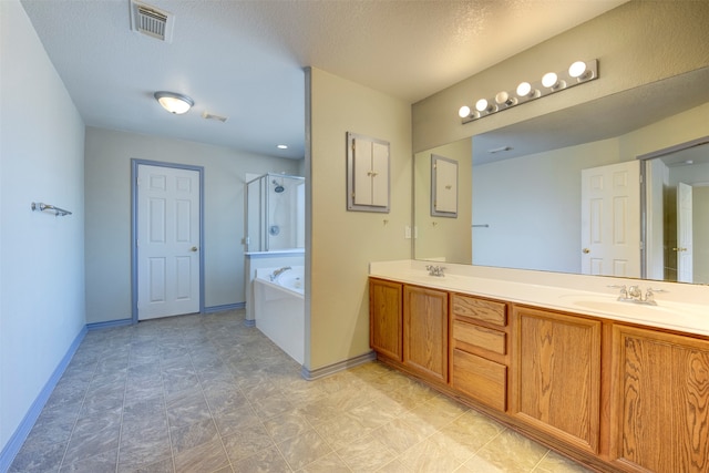 bathroom featuring vanity, a textured ceiling, and independent shower and bath