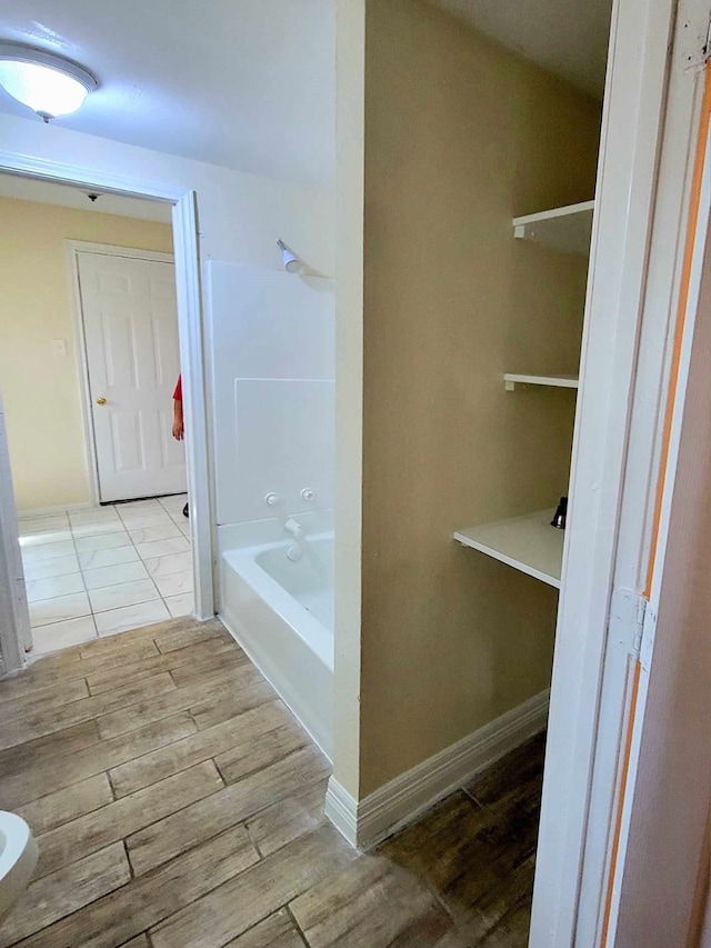 bathroom with wood-type flooring and shower / tub combination