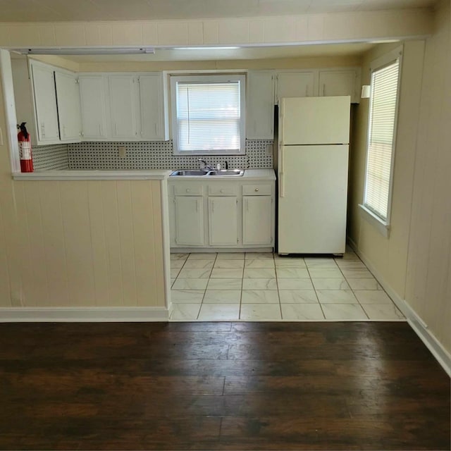 kitchen with light hardwood / wood-style flooring, white fridge, a healthy amount of sunlight, and sink