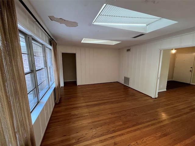 unfurnished room with dark hardwood / wood-style floors and wooden walls