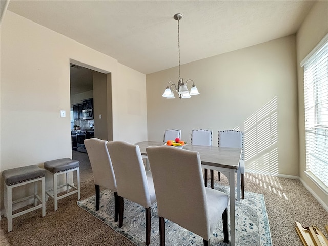 carpeted dining room featuring a chandelier