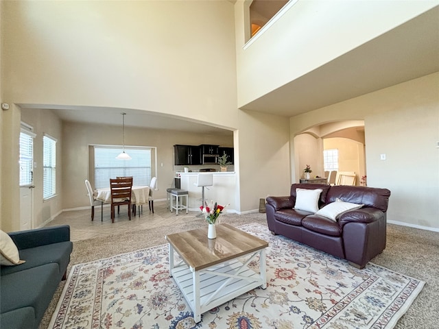 carpeted living room with a towering ceiling