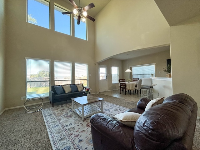 living room with carpet, ceiling fan, and high vaulted ceiling