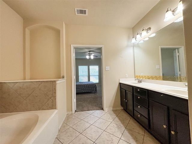 bathroom featuring tile patterned floors, a bath, and vanity