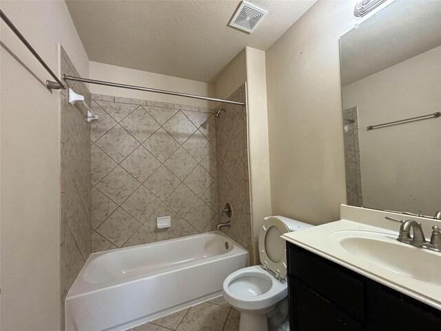 full bathroom with vanity, a textured ceiling, tiled shower / bath combo, tile patterned flooring, and toilet